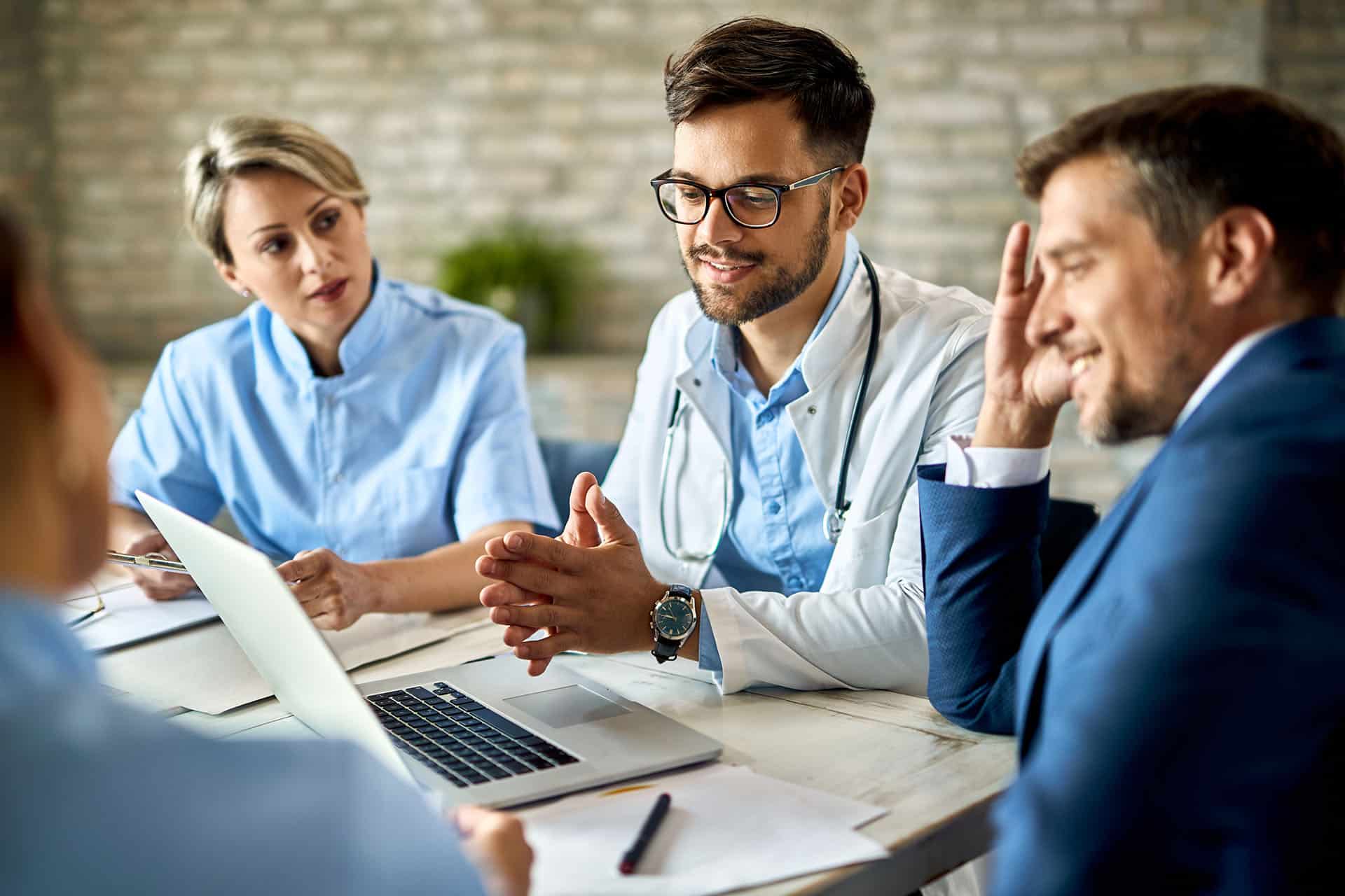Team of doctors using a computer during a meeting Team of doctors using a computer during a meeting