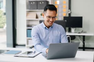 man using laptop and tablet while sitting at his work place